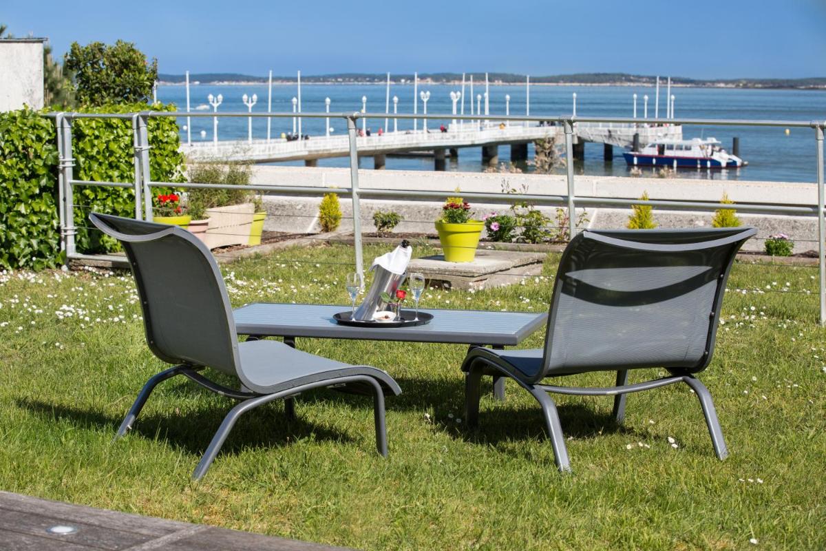 deux chaises et une table avec un ordinateur portable dessus dans l'établissement Hôtel Point France, à Arcachon