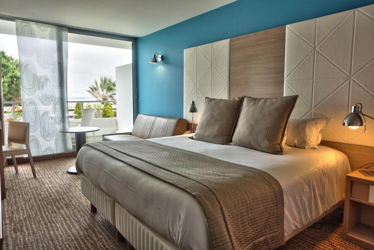 une chambre avec un grand lit et une grande fenêtre dans l'établissement Hôtel Point France, à Arcachon