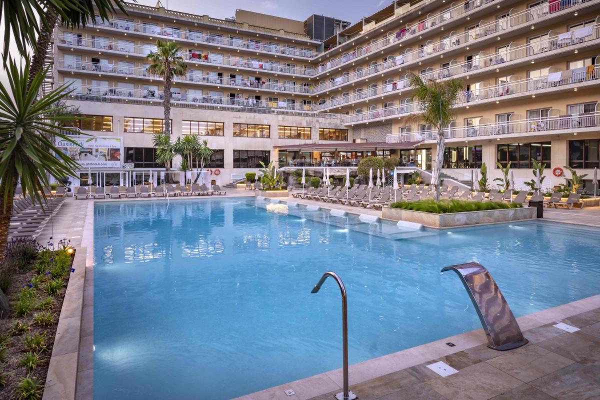 una gran piscina frente a un edificio en GHT Oasis Park & Spa, en Lloret de Mar
