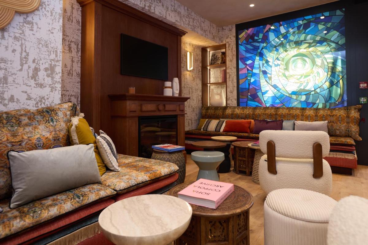 - un salon avec un canapé et un vitrail dans l'établissement Hôtel Hiro Paris, à Paris