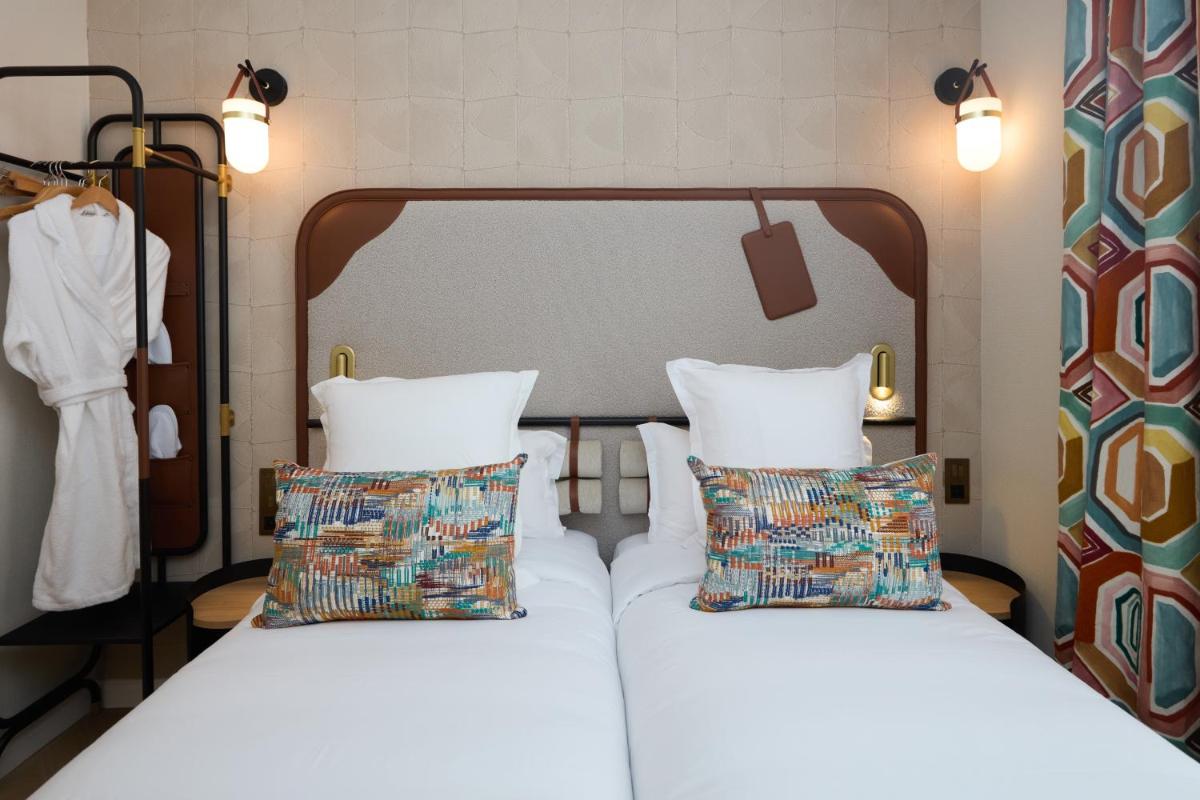 Un ou plusieurs lits dans un hébergement de l'établissement Hôtel Hiro Paris