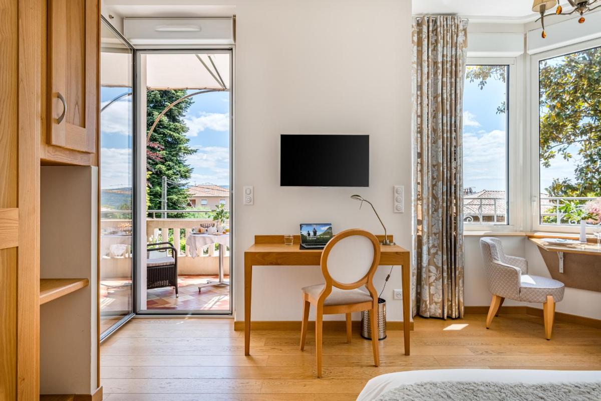 une chambre d'hôtel avec un bureau et une fenêtre dans l'établissement Villa Elisa M, à Aubenas