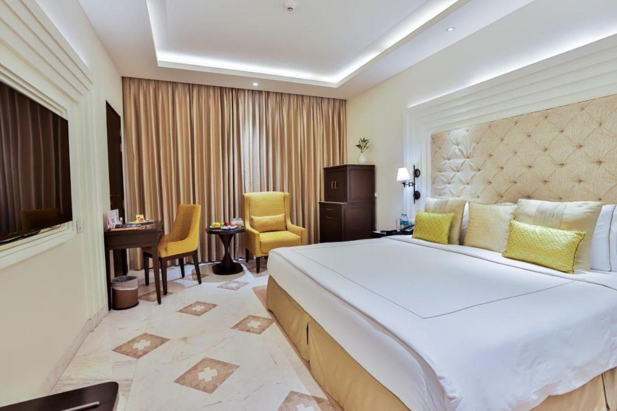 a hotel room with a large bed and a desk at Taj Ganges Varanasi in Varanasi