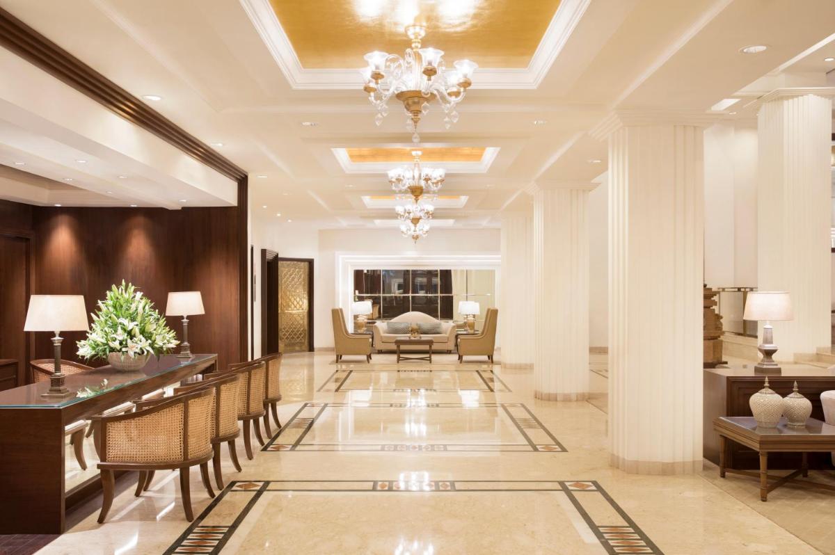 a hotel lobby with a chandelier and a living room at Taj Ganges Varanasi in Varanasi