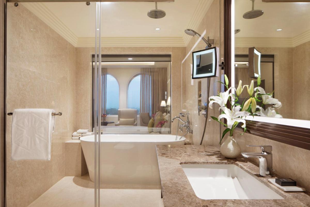 a bathroom with a tub and a sink and a mirror at Taj Ganges Varanasi in Varanasi