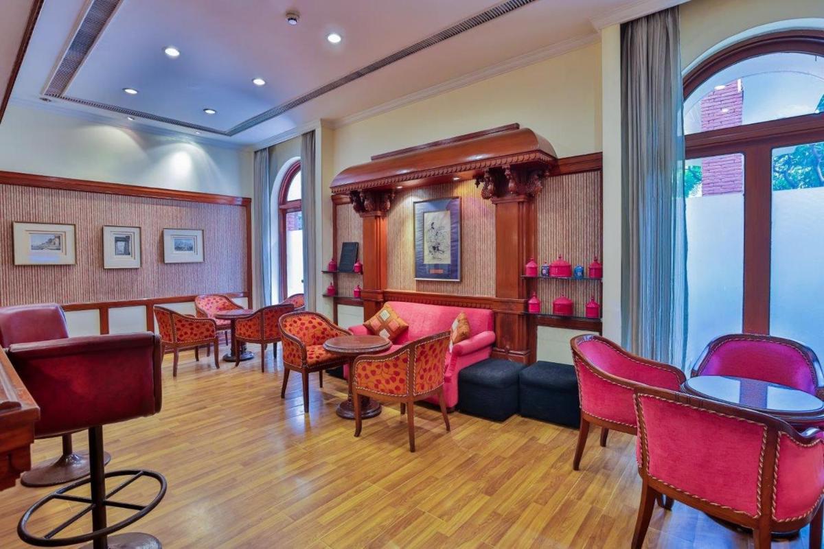 a room with red chairs and tables in a room at Taj Ganges Varanasi in Varanasi