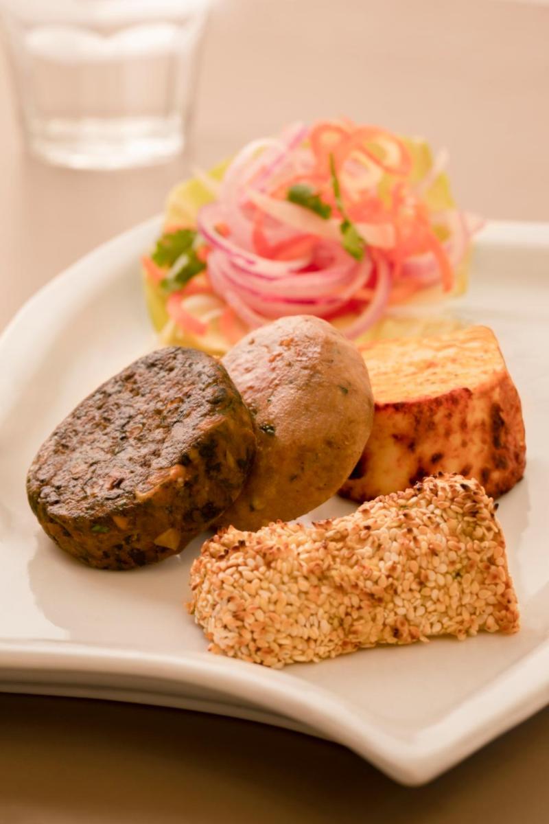 a plate of food with meat and vegetables on a table at Taj Ganges Varanasi in Varanasi