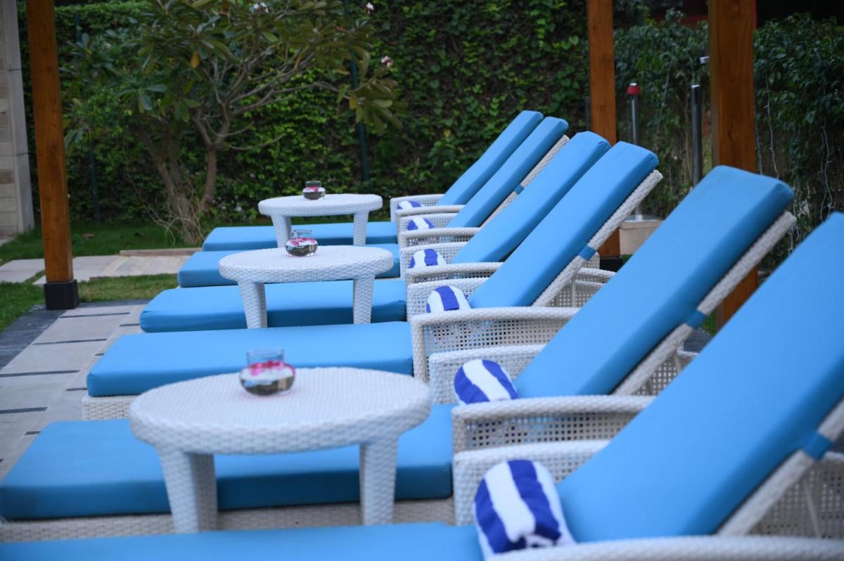 a row of blue chairs and tables on a patio at Taj Ganges Varanasi in Varanasi