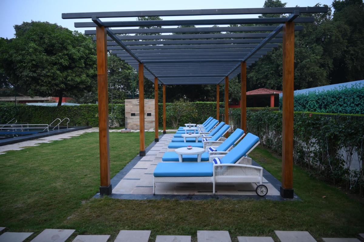 a row of blue lounge chairs in a yard at Taj Ganges Varanasi in Varanasi