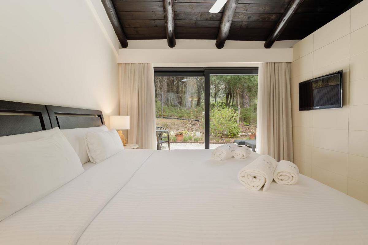 Un dormitorio con una gran cama blanca con toallas. en Shanti Som, en Monda