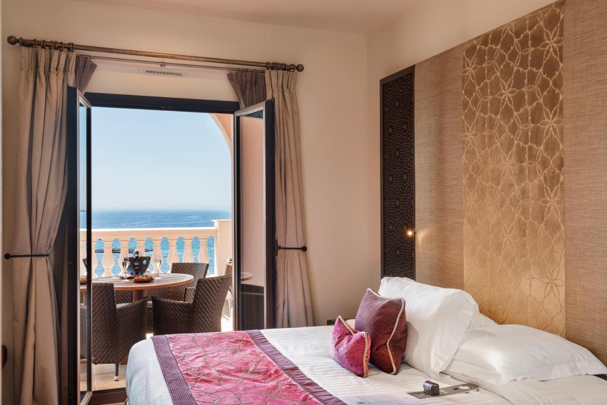 une chambre avec un lit et une vue sur l'océan dans l'établissement Tiara Miramar Beach Resort, à Théoule-sur-Mer