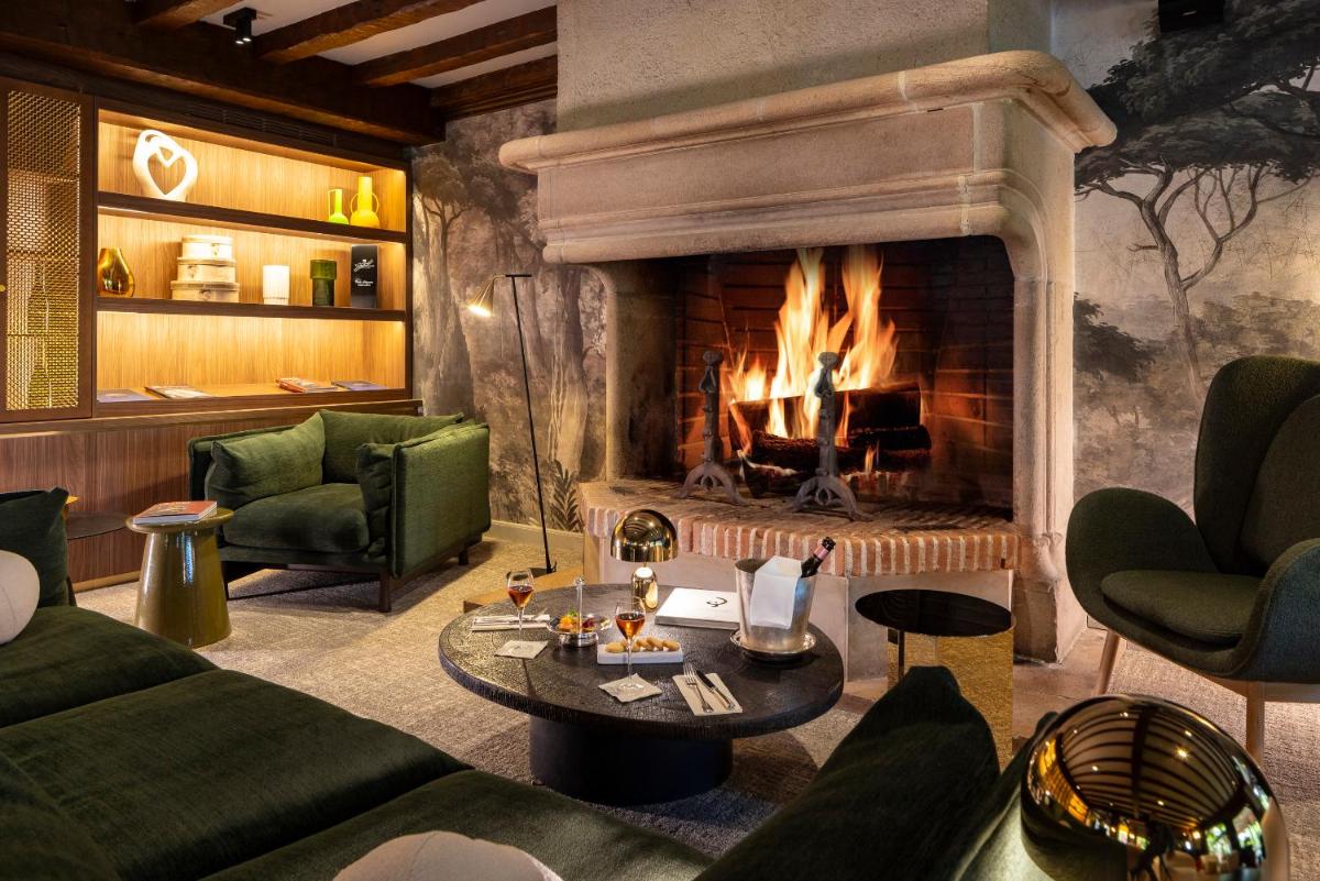 - un salon doté d'une cheminée et d'un mobilier vert dans l'établissement Briqueterie Champagne, A Beauvallon Hotel, à Vinay