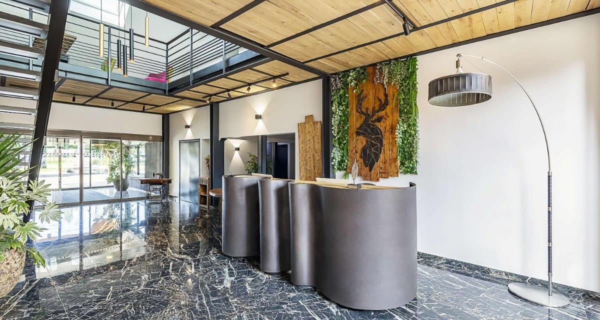 un hall avec une rangée de tables dans une pièce dans l'établissement Best Western Amarys Hotel & Spa, à Rambouillet