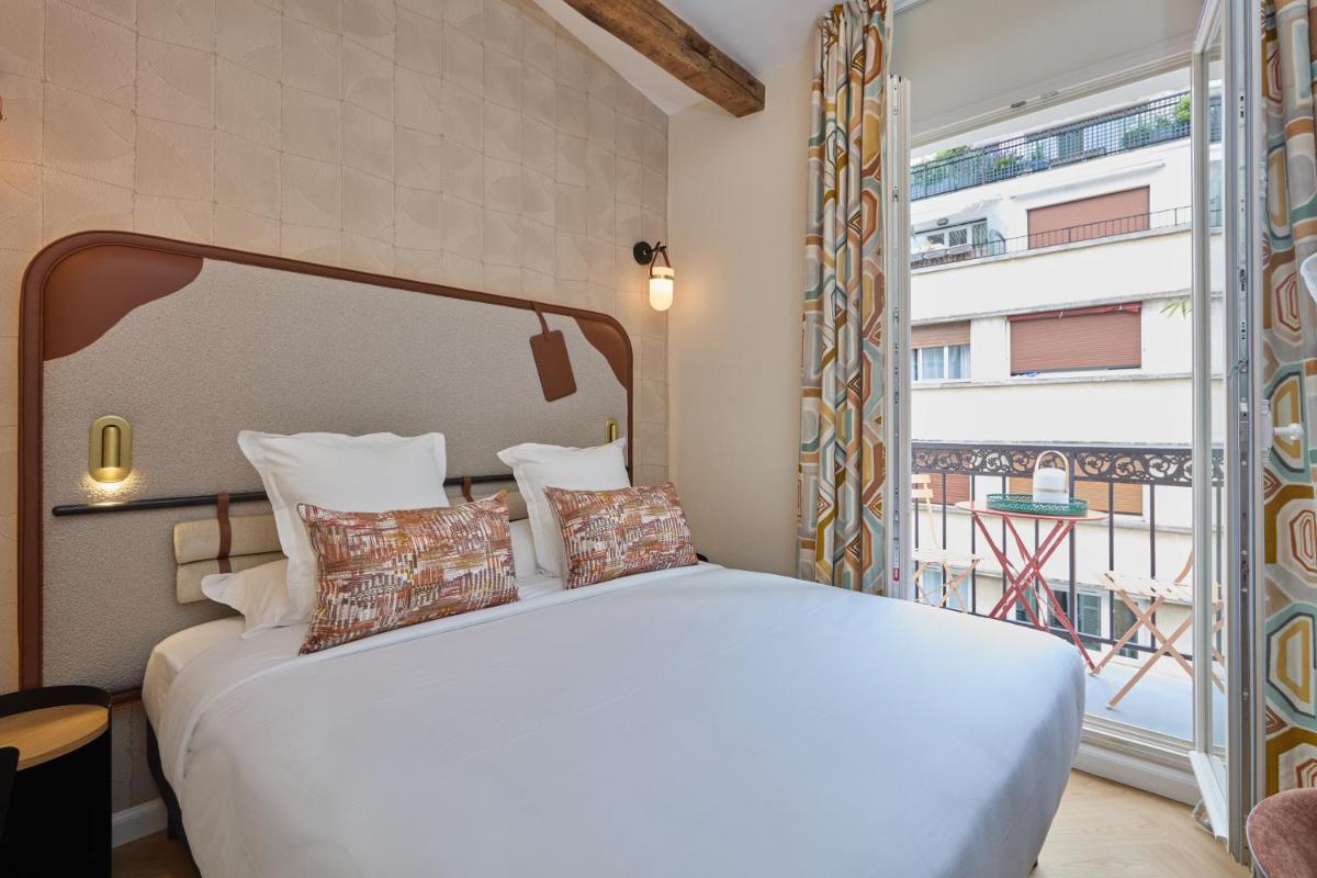 une chambre avec un lit blanc et une grande fenêtre dans l'établissement Hôtel Hiro Paris, à Paris