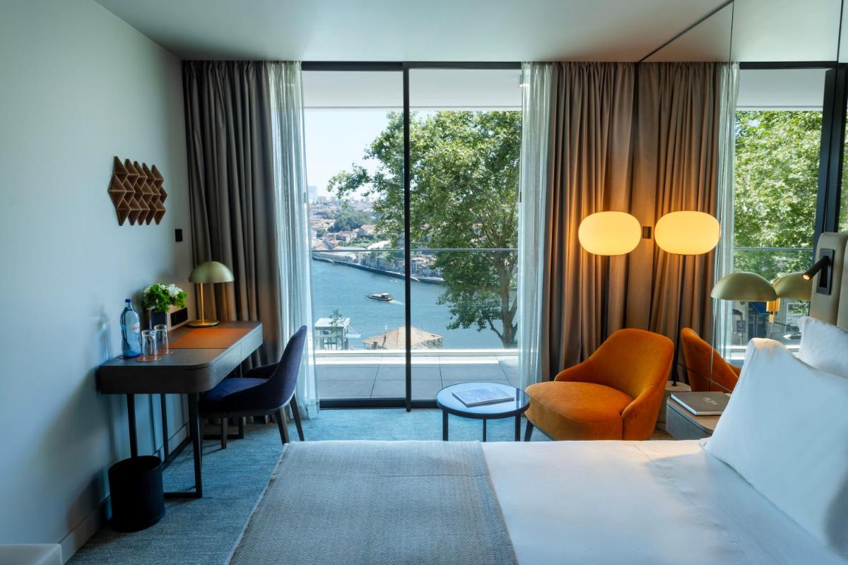 um quarto de hotel com uma cama, uma escrivaninha e uma janela em Altis Porto Hotel no Porto