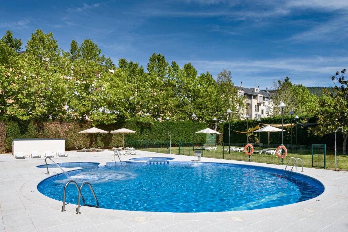 una gran piscina en un patio con sombrillas en Oroel Hotel & SPA, en Jaca