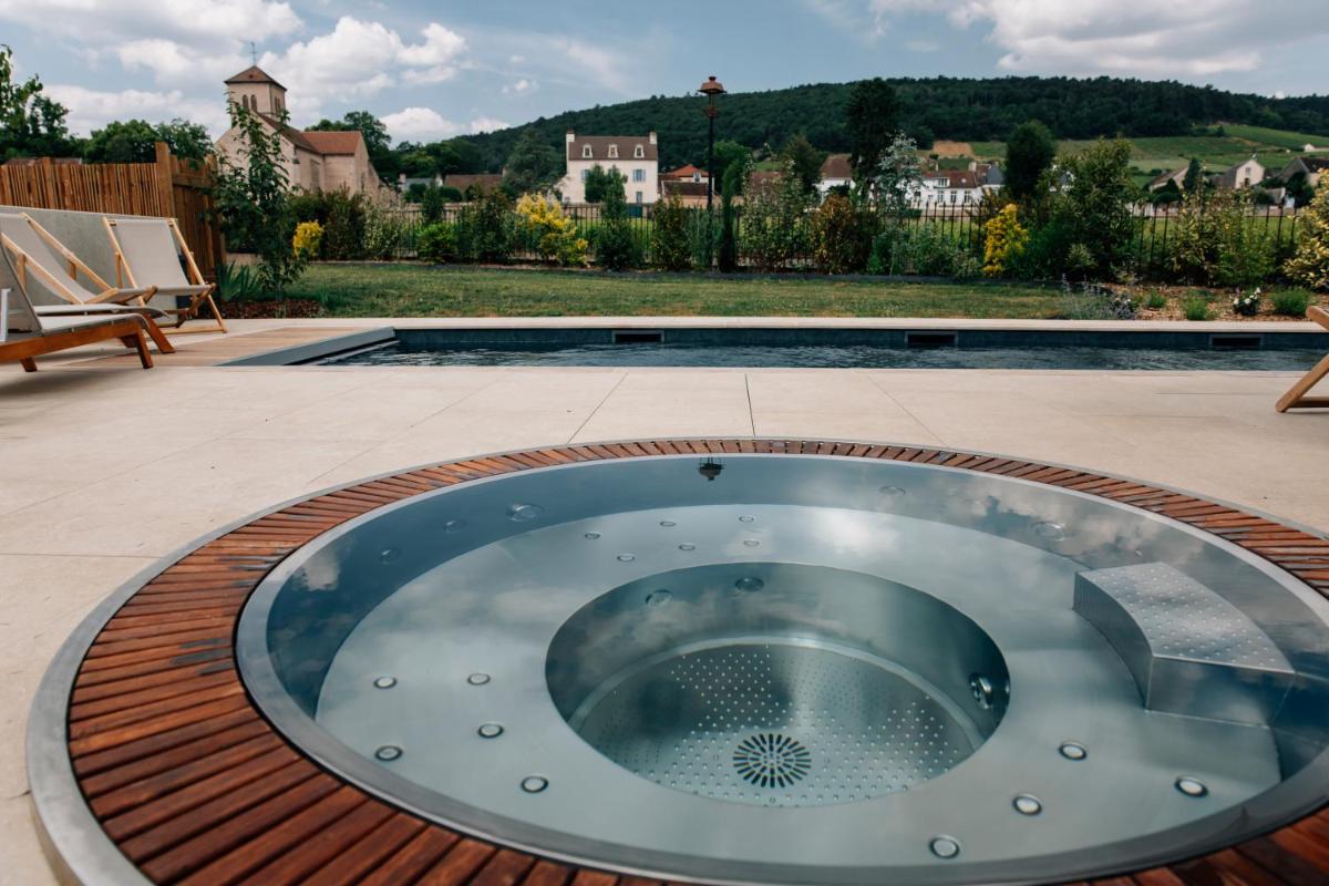 - un bain à remous sur une terrasse à côté d'une piscine dans l'établissement Hôtel-Spa Ô Rouge - Gevrey-Chambertin - Teritoria, à Gevrey-Chambertin
