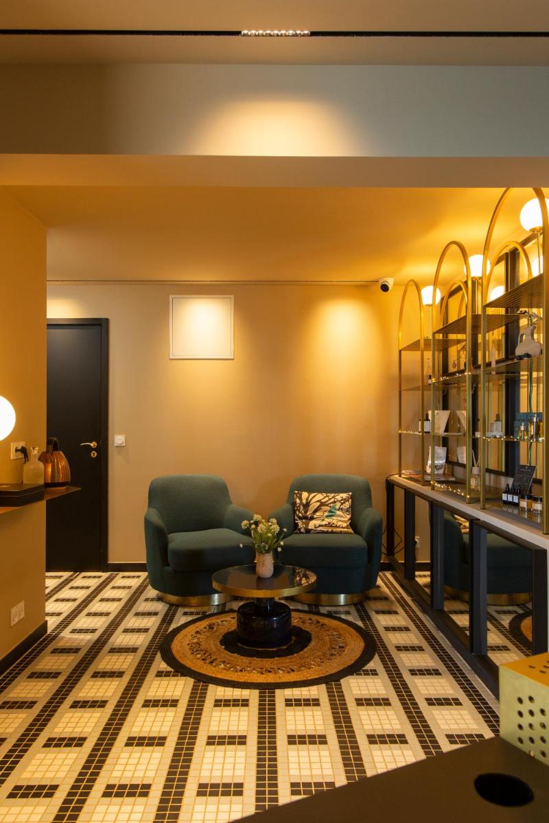 un salon avec deux chaises et une table dans l'établissement Hotel La Pietra Restaurant & Spa, à LʼÎle-Rousse