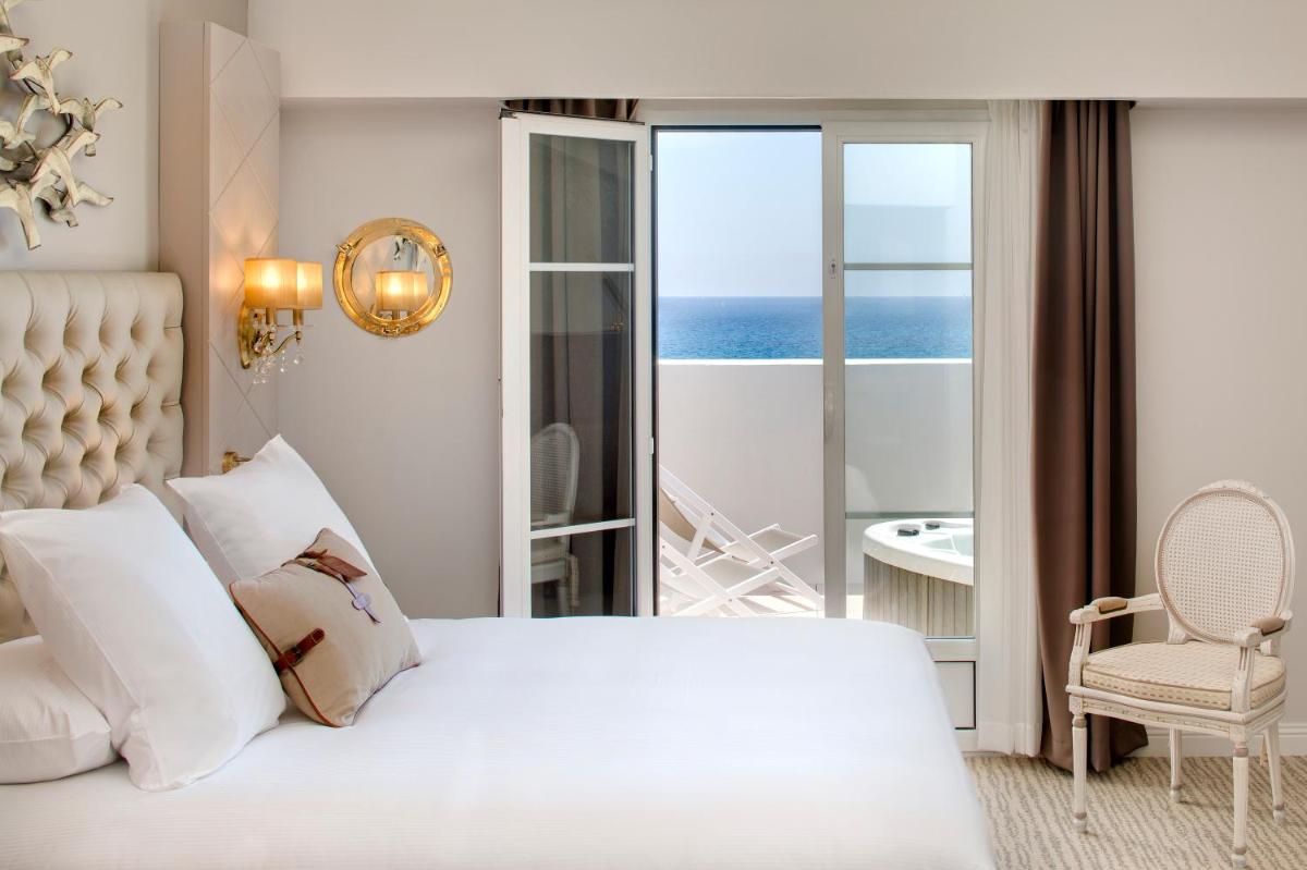 une chambre avec un lit avec vue sur l'océan dans l'établissement Grand Hotel Des Sablettes Plage, Curio Collection By Hilton, à La Seyne-sur-Mer