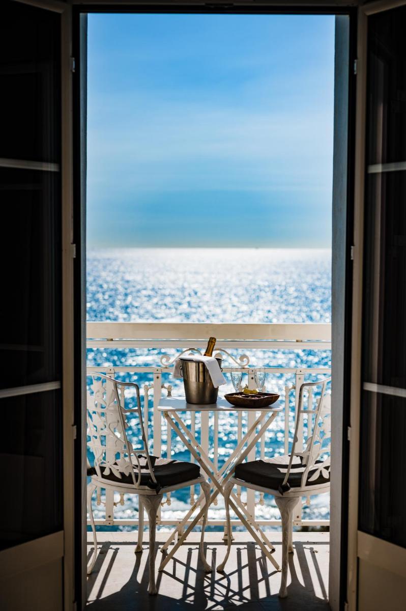 une table et des chaises sur un balcon avec l'océan dans l'établissement Grand Hotel Des Sablettes Plage, Curio Collection By Hilton, à La Seyne-sur-Mer