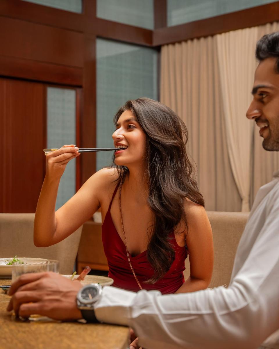 a woman eating food with a spoon in her mouth at Hyatt Pune in Pune