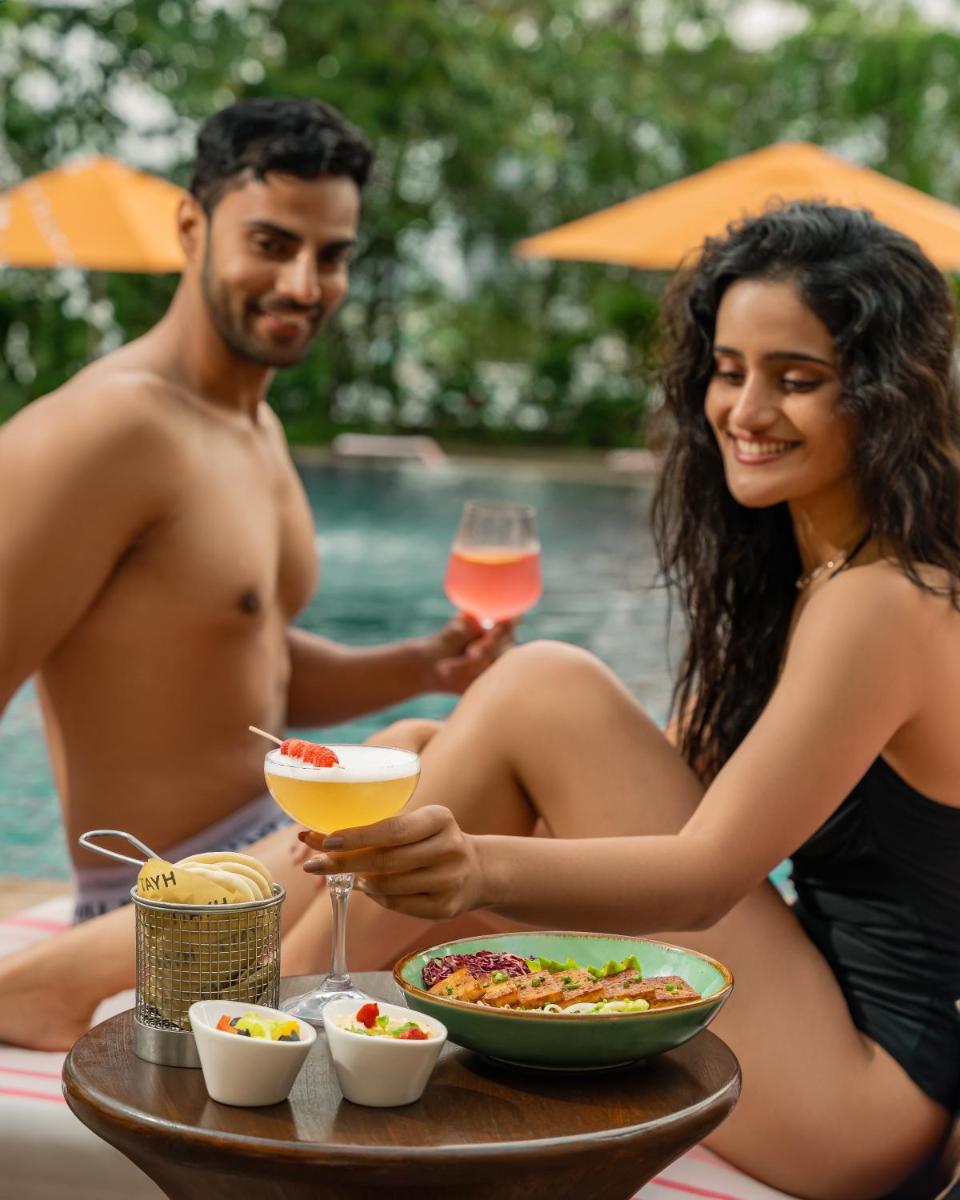 a man and woman sitting at a table with food and drinks at Hyatt Pune in Pune