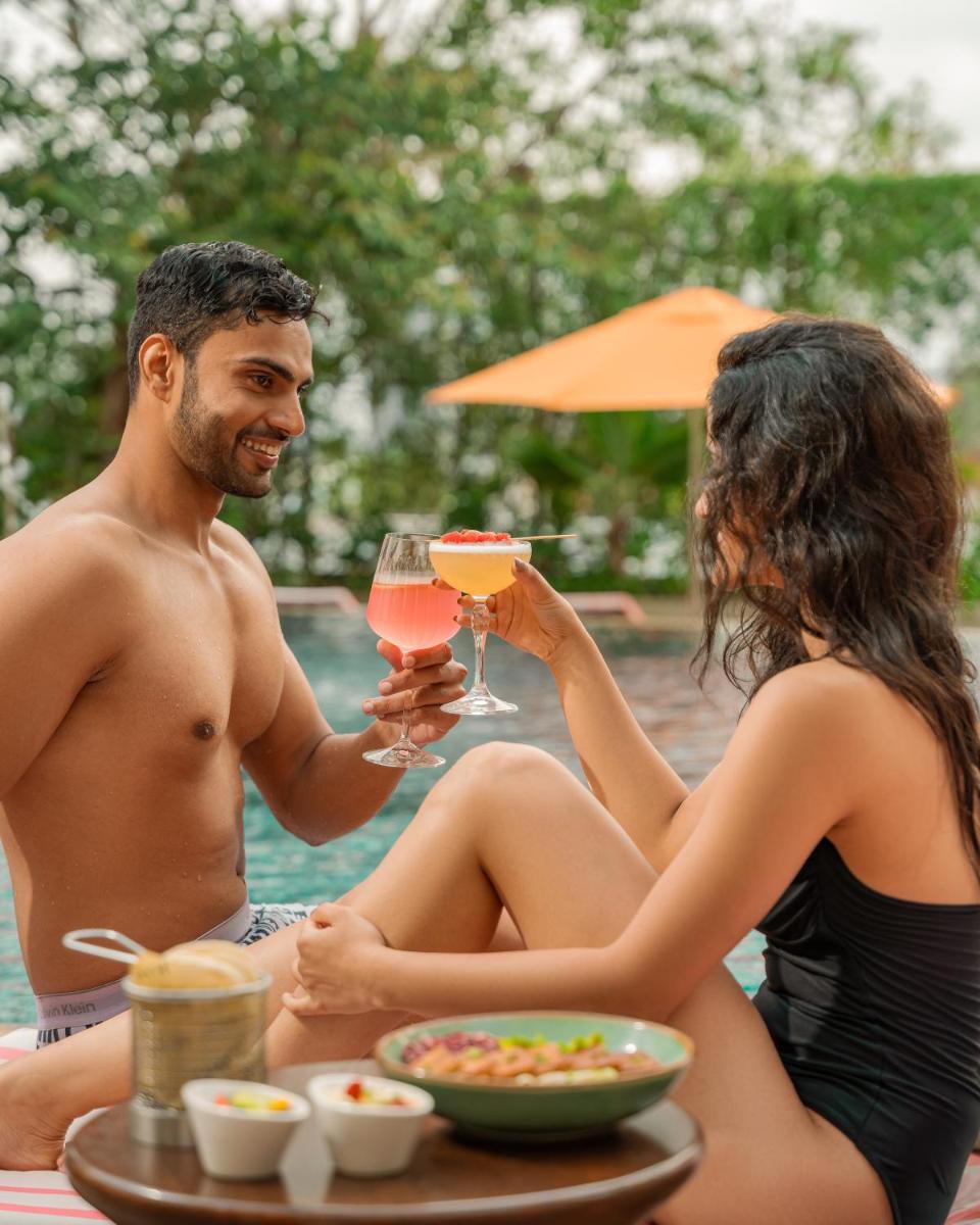 a man and woman sitting at a table with a glass of wine at Hyatt Pune in Pune