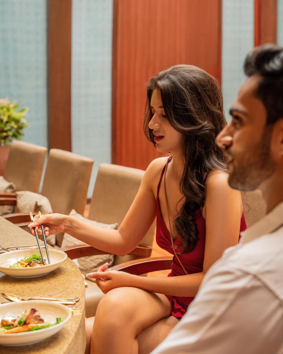 a man and a woman sitting at a table eating food at Hyatt Pune in Pune
