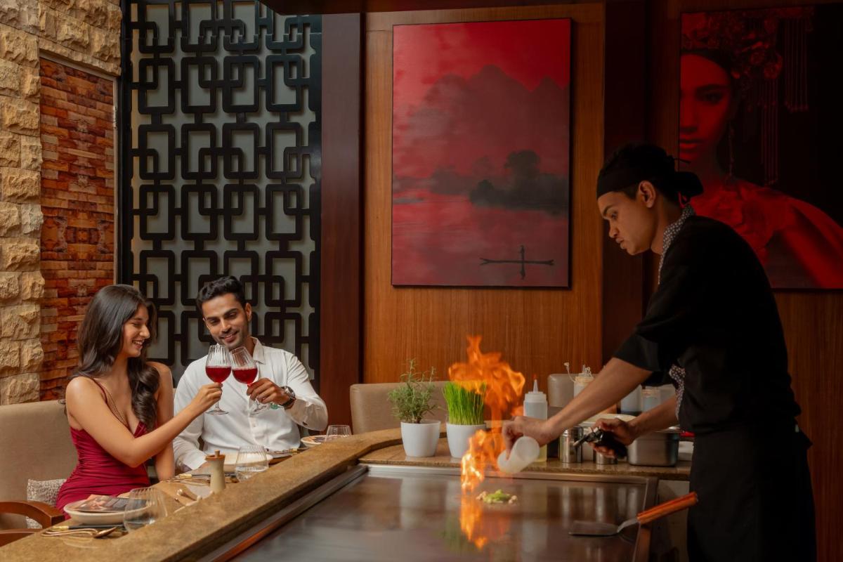a group of people sitting around a table in a restaurant at Hyatt Pune in Pune