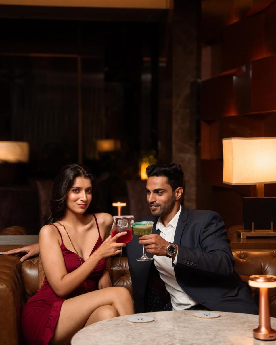 a man and woman sitting on a couch holding drinks at Hyatt Pune in Pune