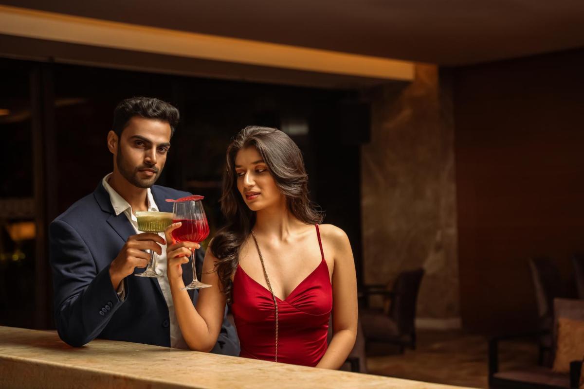 a man and a woman sitting at a table with a drink at Hyatt Pune in Pune