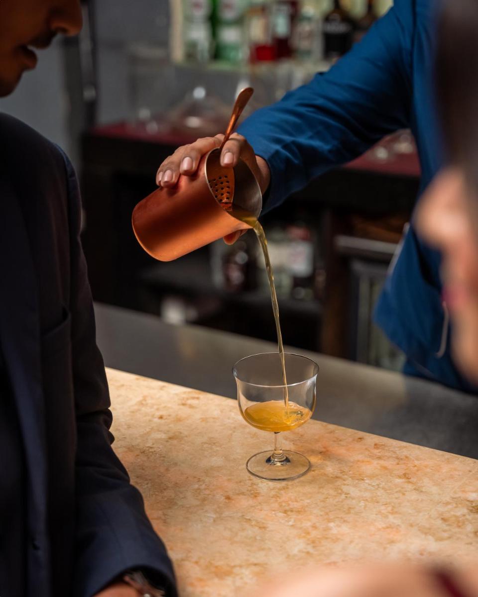 a person pouring a drink into a glass at Hyatt Pune in Pune