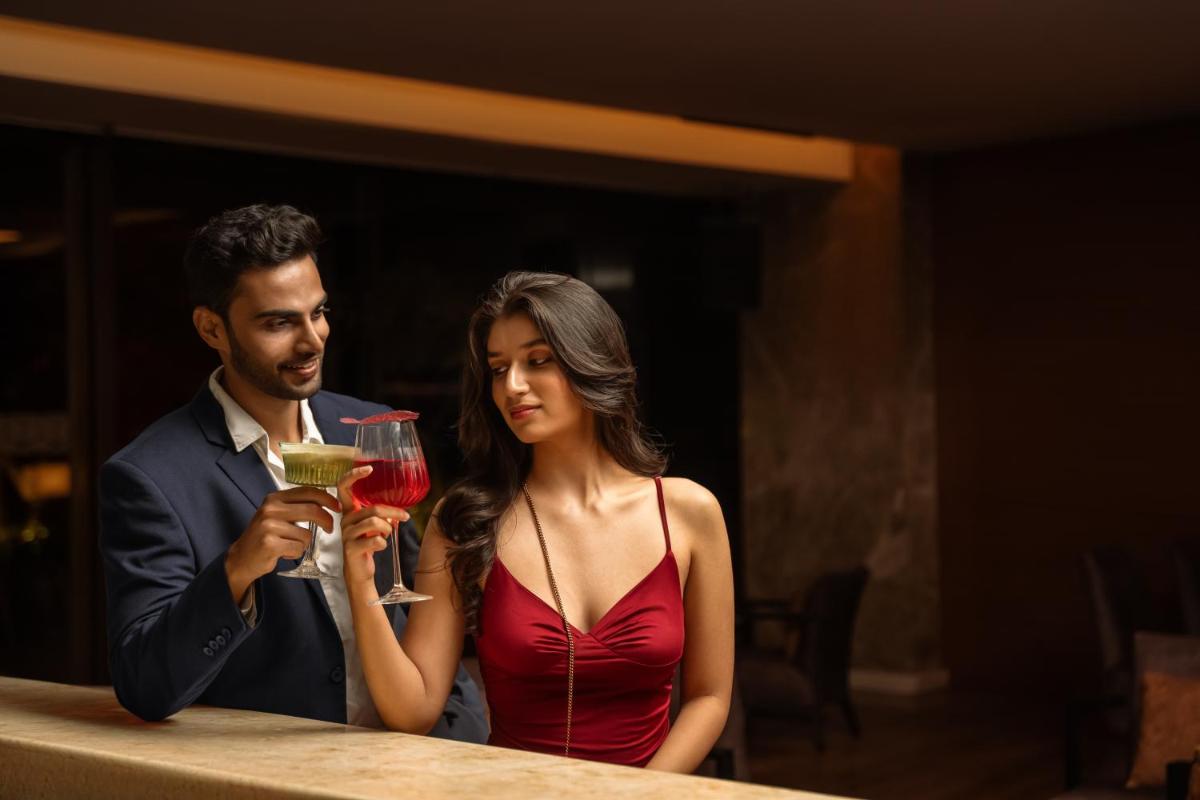 a man and a woman sitting at a table with a drink at Hyatt Pune in Pune