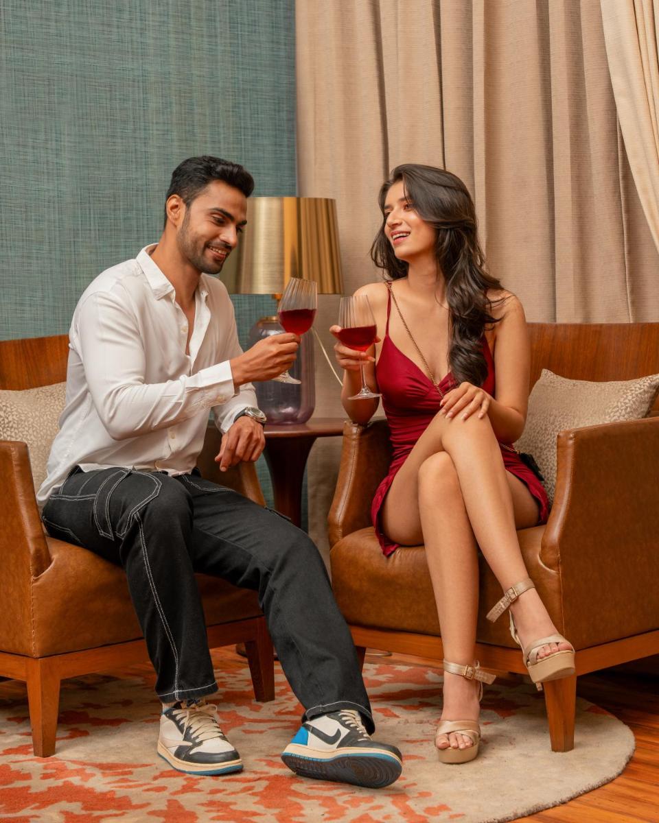 a man and a woman sitting in chairs holding wine glasses at Hyatt Pune in Pune