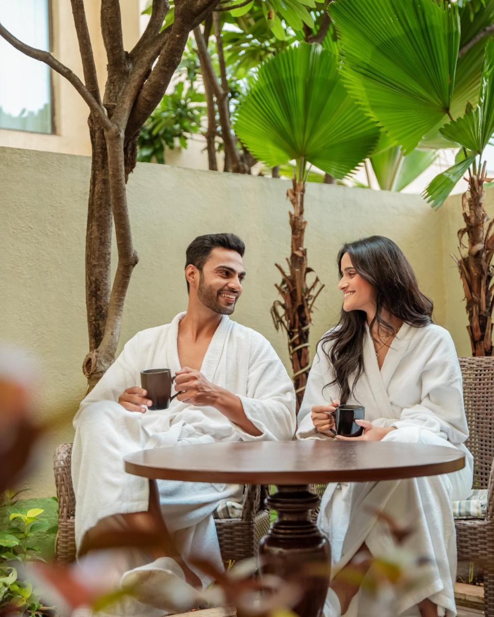 a man and woman sitting at a table with cups of coffee at Hyatt Pune in Pune