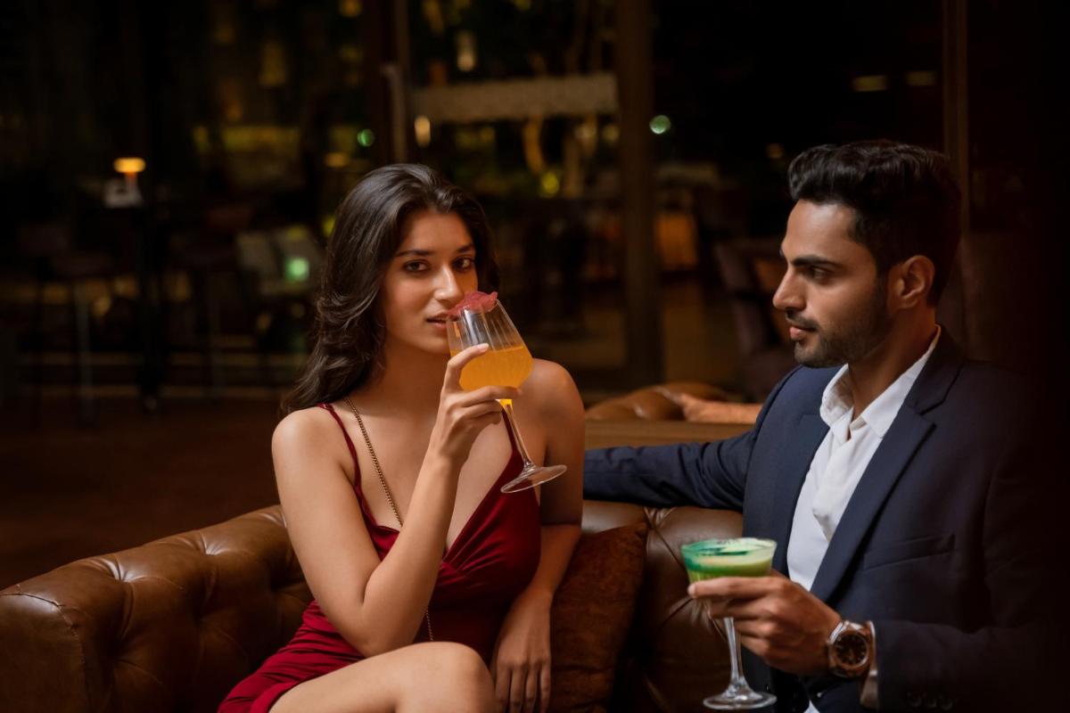 a man and a woman sitting on a couch with a drink at Hyatt Pune in Pune