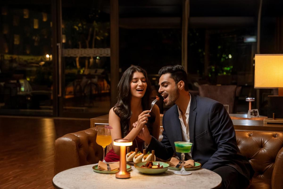 a man and woman sitting at a table in a restaurant at Hyatt Pune in Pune