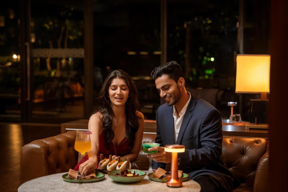 a man and a woman sitting at a table with food at Hyatt Pune in Pune