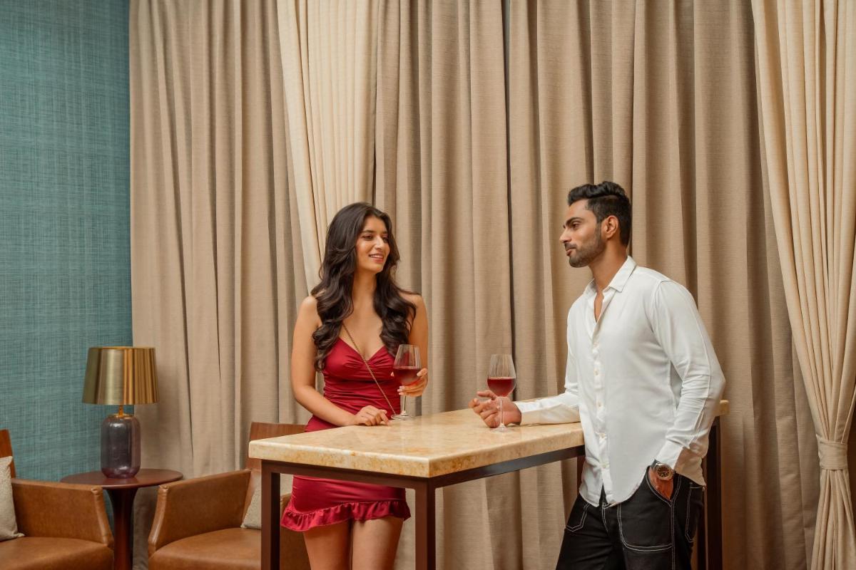a man and woman standing at a table with wine glasses at Hyatt Pune in Pune