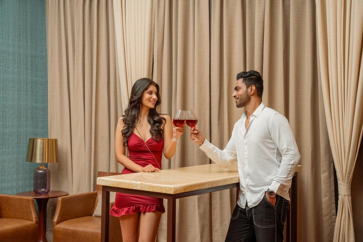 a man and woman standing at a table with a glass of wine at Hyatt Pune in Pune