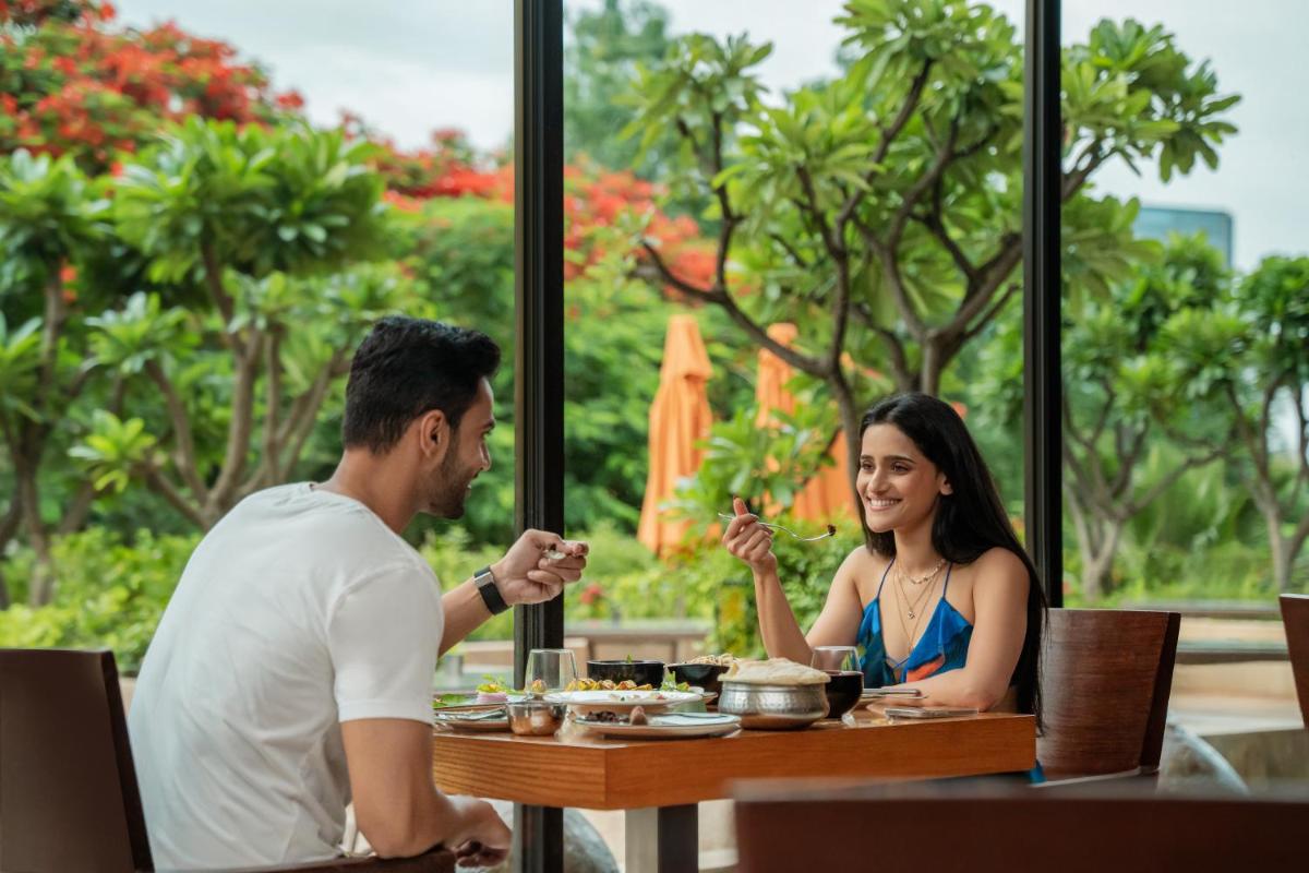 a man and woman sitting at a table in a restaurant at Hyatt Pune in Pune