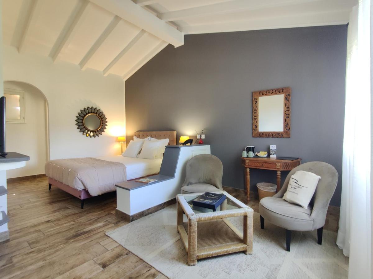 une chambre avec un lit et une chaise dans l'établissement Le Roc E Fiori Hotel - Teritoria, à Porto-Vecchio