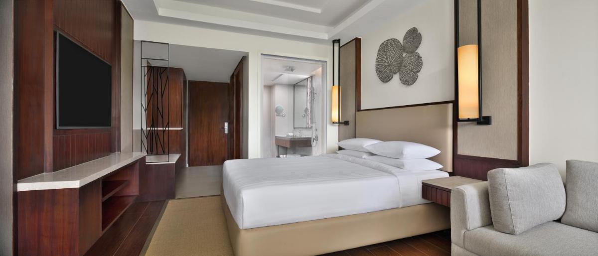 a bedroom with a bed and a tv and a couch at Courtyard by Marriott Mahabaleshwar in Mahabaleshwar
