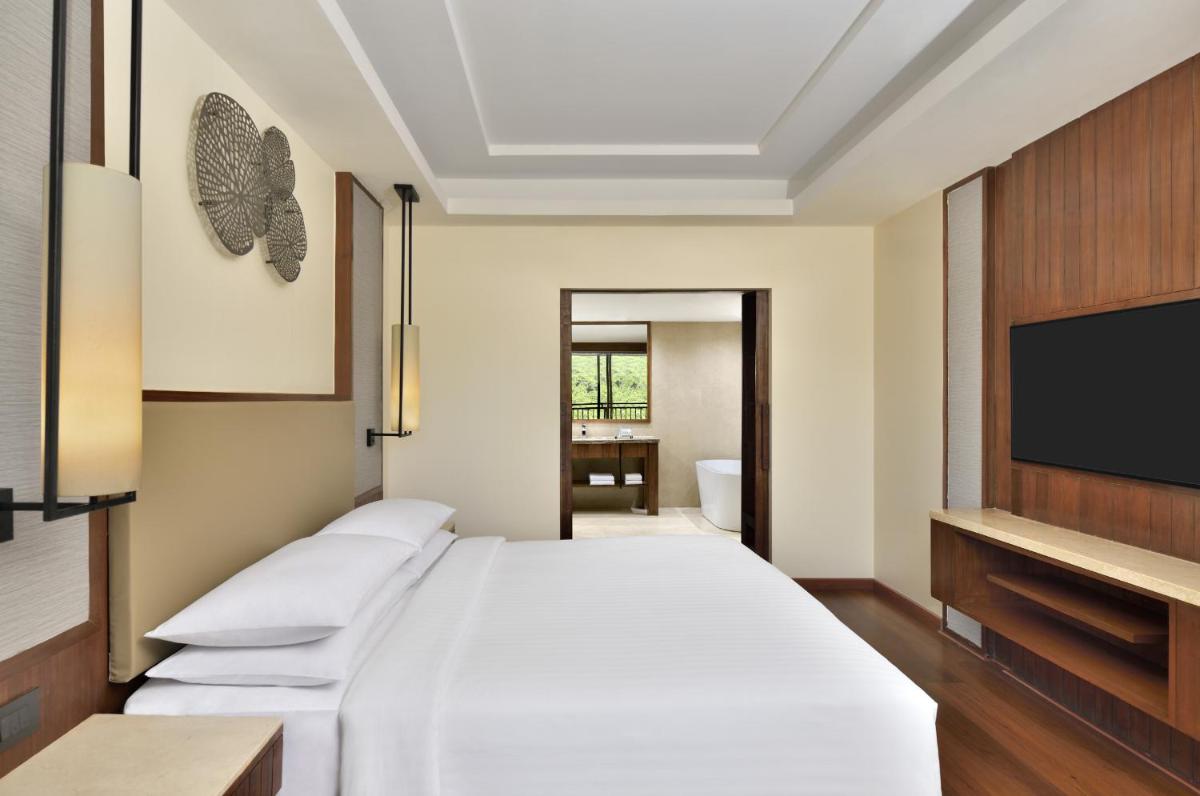 a bedroom with a bed and a flat screen tv at Courtyard by Marriott Mahabaleshwar in Mahabaleshwar