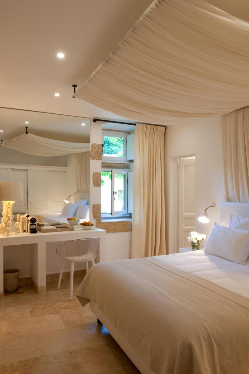 une chambre avec un grand lit et une cuisine dans l'établissement Le Vieux Castillon, à Castillon-du-Gard