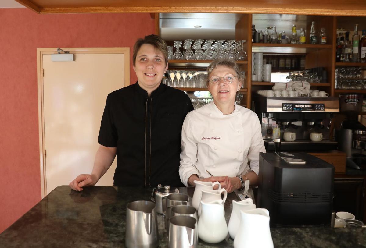 Deux femmes se tenant derrière un comptoir dans une cuisine dans l'établissement Logis Hotel Spa Restaurant Le Provence, à Lanarce 115 autres photos