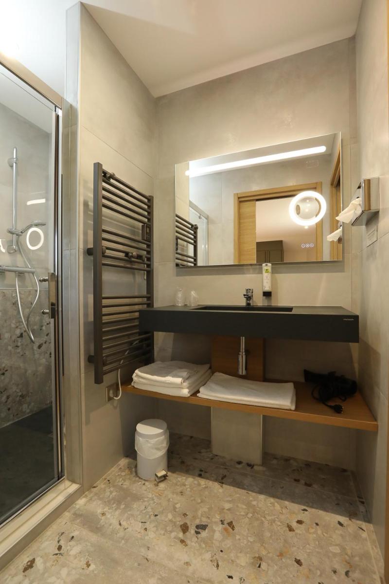une salle de bain avec un lavabo et un miroir dans l'établissement Logis Hotel Spa Restaurant Le Provence, à Lanarce