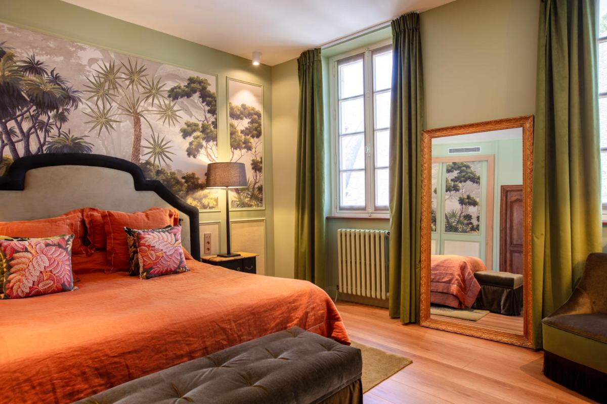une chambre avec un lit et un miroir dans l'établissement Hôtel Le Cep & Spa, à Beaune