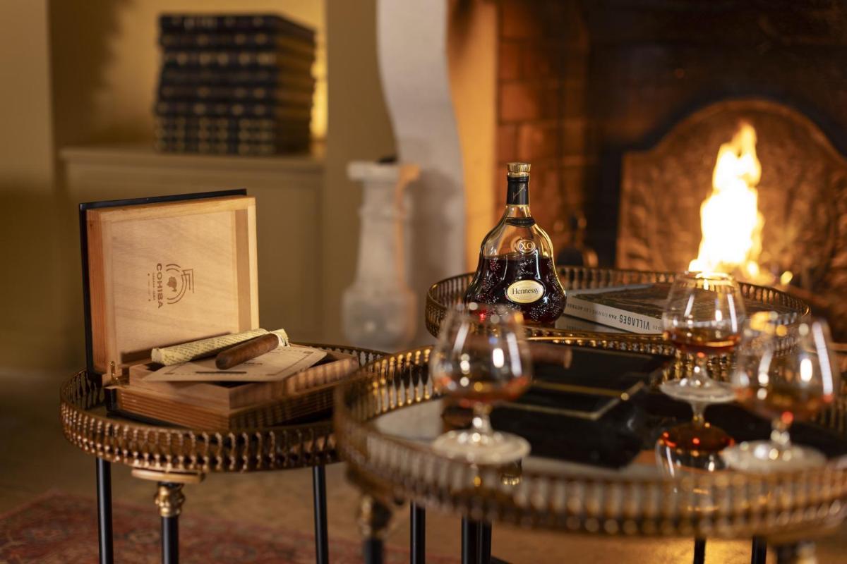 une table avec une bouteille de vin et des verres à vin dans l'établissement Château Les Oliviers de Salettes, à Charols