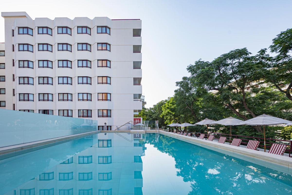 un hotel con piscina frente a un edificio en Hesperia Sevilla, en Sevilla